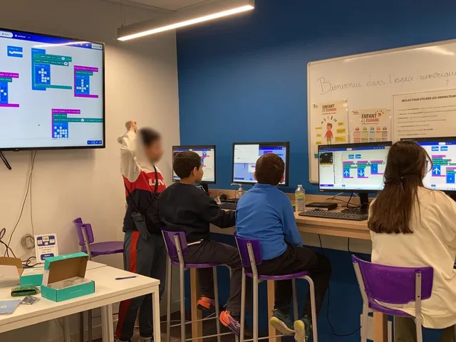 Groupe d'ados codant en atelier, univers Cutebot affiché au projecteur