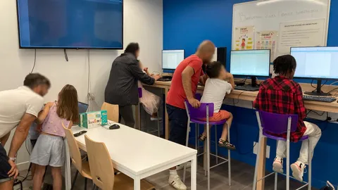 Parents et enfants codant ensemble lors d'un atelier parentalité